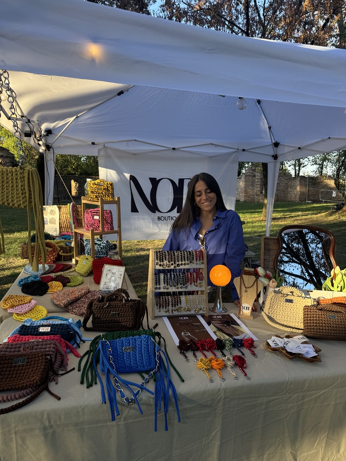 Stefania al banco di Node Boutique, tra borse e accessori all’uncinetto esposti al mercatino